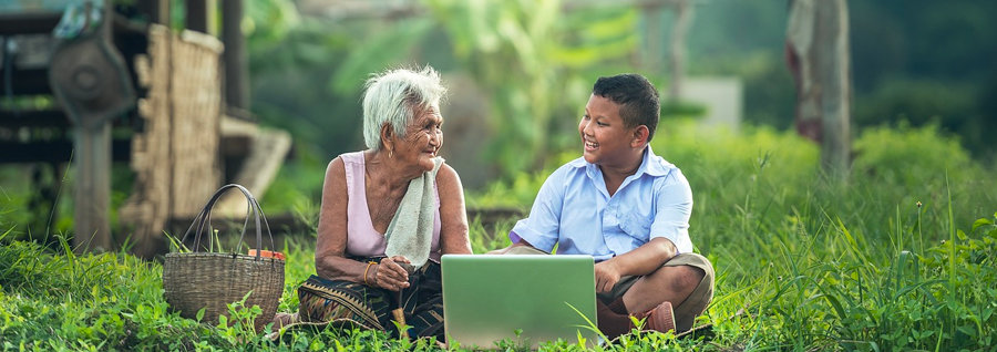 Abuela y niño en la naturaleza con portátil